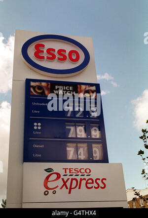 A forecourt sign at an Esso petrol station in London, showing prices for petrol. Also on the sign is a notice for a Tesco Express supermarket. Stock Photo