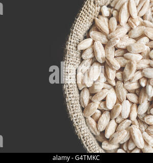 grain barley in flax sack on grey background Stock Photo