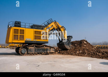 A 285 tonne crawler excavator at the XCMG excavator production facility in Xuzhou, China with a mound of earth. Stock Photo