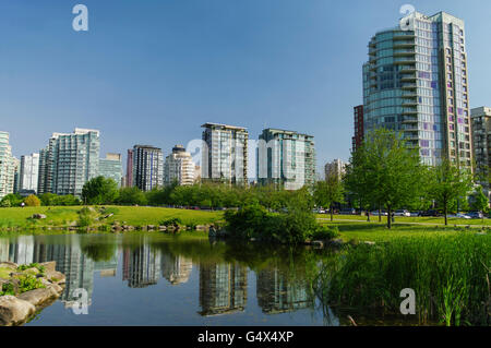View of Vancouver from Devonian Harbour Park, across a pond in which high-rise buildings are reflected. British Columbia, Canada Stock Photo