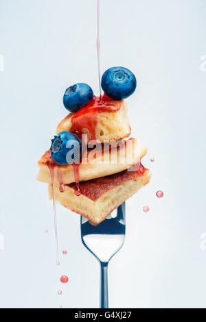 Pancakes with blueberry and syrup on fork Stock Photo