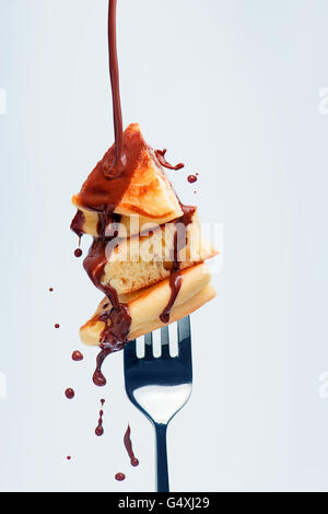 Pancakes with chocolate sauce on fork Stock Photo
