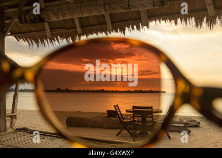 Indonesia, Nusa Tenggara Barat, Lombok Utara, looking through the sunglasses over the sea at sunset Stock Photo