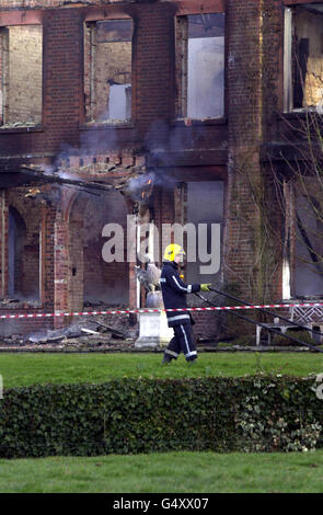 Firefighters hose down the home of Tory MP Michael Colvin after fire swept through his country mansion. Rescuers were searching for Mr Colvin and his wife Nichola at the country mansion after fire gutted their home, Tangley House, near Andover in Hampshire. * About 70 firefighters and 10 fire appliances were at the scene damping down the house which has been 95% destroyed. Stock Photo