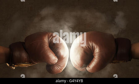 Two brown old boxing gloves hit together Stock Photo
