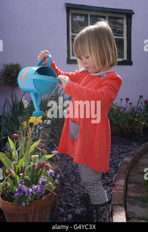 child watering garden with watering can Stock Photo