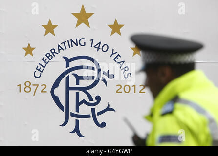 Soccer - Rangers Enter Administration. A policeman walks past a poster at Ibrox Stadium, home of Rangers FC in Glasgow, Scotland. Stock Photo