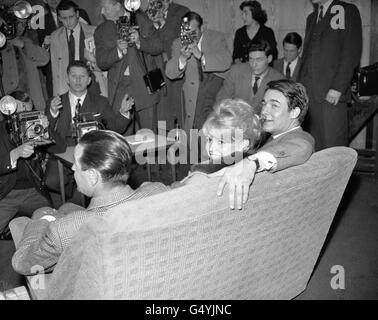 Brigitte Bardot at London's Heathrow Airport, London poses with her leading man Jacques Charrier (right) and director Christian Jacque after arriving from Paris to start location shooting of her latest movie 'Babette Goes to War' Stock Photo