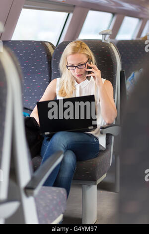 Business woman working while travelling by train. Stock Photo