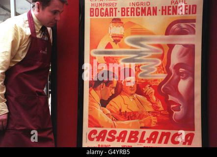 A porter admires a poster for the classic film Casablanca, at Christie's in South Kensington. Christie's will hold a Vintage Film Poster Sale on 27 /3/2000. *27/03/2000 - The film poster for the cult classic Casablanca sold for a record 53,300 at Christie's, South Kensington, in London. The film starred Humphrey Bogart and Ingrid Bergman and was made in 1942. It has regularly appeared in lists of top 10 Hollywood films. Stock Photo