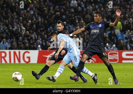 Manchester City's David Pizarro (centre) shoots to score his team's fourth goal, as he is challenged by FC Porto's Steven Defour (left) and Lobo Alex Sandro Stock Photo