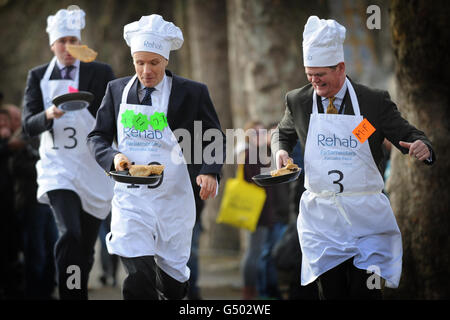 (left - right), Rob Hutton from Bloomberg Lord Listowel, and Stephen Lloyd MP take part in the annual Parliamentary Pancake Race in Westminster today raising money for the charity Rehab. Stock Photo