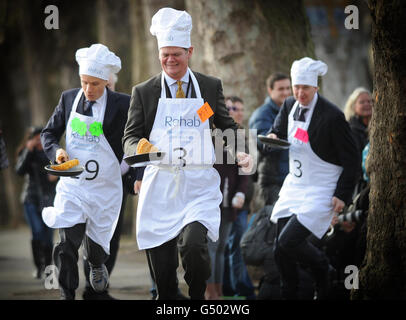 (left - right) Lord Listowel, Stephen Lloyd MP and Rob Hutton from Bloomberg take part in the annual Parliamentary Pancake Race in Westminster today raising money for the charity Rehab. Stock Photo