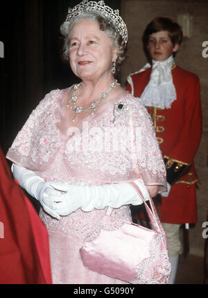 The Queen Mother in her robes as University chancellor, at the University of London when she attended the Foundation day dinner and conferred honorary degrees. Carrying her train is Mr Henry Beaumont. Stock Photo