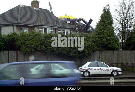 The wreckage of a police helicopter on the roof of a house after the helicopter spun out of the sky and crashed through the roof. Three crew members emerged unscathed from the crash on to the two-storey semi in the quiet Whitchurch area of Cardiff. * The aircraft developed a fault while chasing a stolen car. Stock Photo