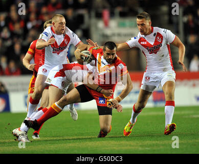 Catalan Dragons Vincent Duport (centre) is tackled by St Helens' Gary Wheeler, Lee Gaskell and Jamie Foster during the Stobart Super League match at Langtree Park, St Helens. Stock Photo