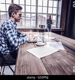 Woman waiting for man finishing work in office Stock Photo