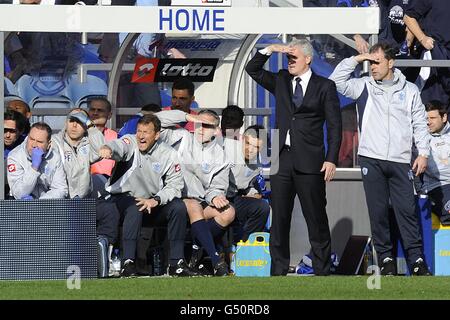 Queens Park Rangers manager Mark Hughes (second left) and his assistant Mark Bowen (right) shield their eyes as they stand on the touchline Stock Photo