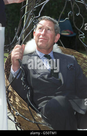 The Prince of Wales, tries out a wrought iron hanging chair suspended from three tree trunks made by blacksmith Caroline Fletcher, 29, from Midhurst. * The Prince whilst on a visit to Fletching village in East Sussex met with young men and women who have started their own businesses with grant aid from the Prince's Trust. Stock Photo