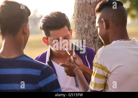 Kids in park smoking cigarette. Concept of smoking and social issues ...