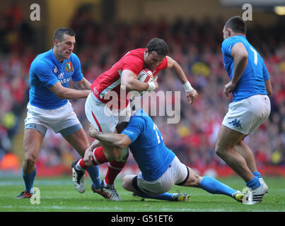 Wales' Jaime Roberts is tackled by Italy's Andrea Masi (bottom right) and Alberto Sgarbi (left) during the RBS 6 Nations match at the Millennium Stadium, Cardiff. Stock Photo