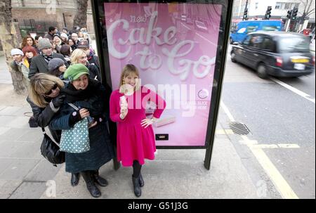 Actress Joanna Page beside a Mr Kipling Cake-To-Go dispenser which has been installed on Tottenham Court Road in London as part of a campaign by the company to help cheer up the nation by spontaneously making cake appear when people least expect it. Stock Photo