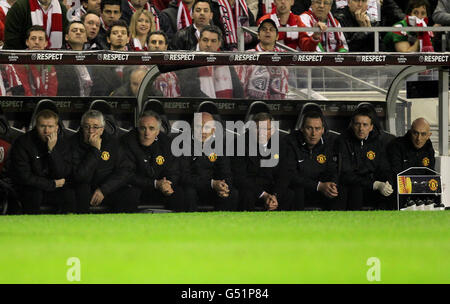 The Manchester United dugout with Paul Scholes (left), assistant manager Mick Phelan (fourth left), first team coach Rene Meulensteen (third right), goalkeeping coach Eric Steele (third left), head physiotherapist Rob Swire (right), kit manager Albert Morgan (second left) and manager Sir Alex Ferguson (fourth right). Stock Photo