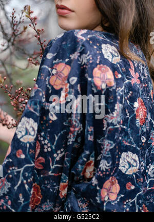 Detail of a woman's lips in front of the spring blossom tree Stock Photo