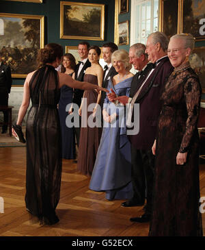 Actress Sofie Grabol (left) greets the Duchess of Cornwall and the Prince of Wales in a receiving line ahead of an official dinner at the Royal Palace in Copenhagen, Denmark. Stock Photo