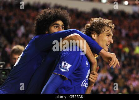 Everton's Nikica Jelavic (right) celebrates with team-mate Marouane Fellaini after his shot is turned in by Sunderland's David Vaughan, resulting in an own goal Stock Photo