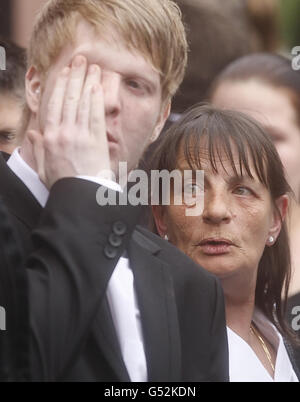 Jocky Wilson's wife Malvina Wilson (right) is pictured with a mourner (name not known) following the funeral of former world champion darts player Jocky Wilson at Kirkcaldy Crematorium in Scotland. Stock Photo