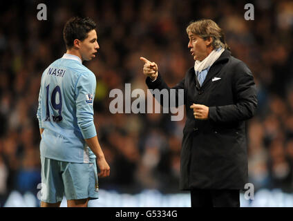 Soccer - Barclays Premier League - Manchester City v West Bromwich Albion - Etihad Stadium. Manchester City's Samir Nasri (left) receives tactical advice from manager Roberto Mancini on the touchline Stock Photo