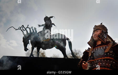 A man dressed as Genghis Khan poses as an eight foot high bronze sculpture of Mongolian warrior Genghis Khan is unveiled at Marble Arch, London. Stock Photo