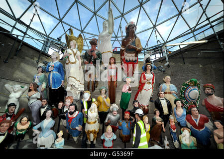 Conservators work in the dry berth under the Cutty Sark in Greenwich, London, as they apply the finishing touches to a display of over 80 figureheads. Stock Photo