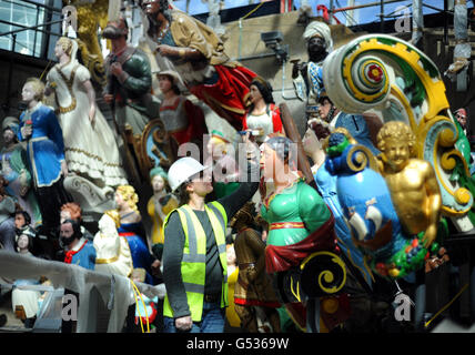 A conservator works in the dry berth under the Cutty Sark in Greenwich, London, as they apply the finishing touches to a display of over 80 figureheads. Stock Photo