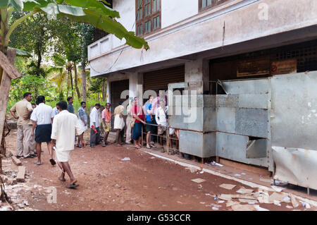 Unidentified People stand in a queue to alcoholic shop. Varkala. Kerala. India Stock Photo