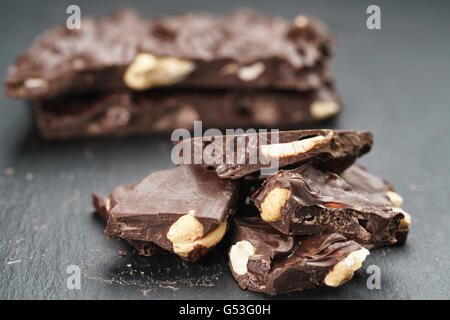 broken homemade bar of chocolate with cashew nuts reverse side Stock Photo