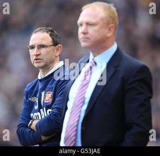 Soccer - Barclays Premier League - Aston Villa v Sunderland - Villa Park. Sunderland's manager Martin O'Neill peers around Aston Villa's manager Alex McLeish Stock Photo