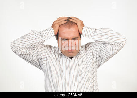 Frustrated man head in hands against a white background Stock Photo