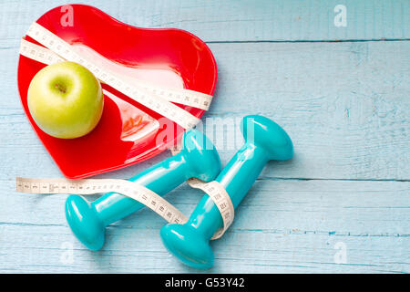Fit and health abstract concept with red heart plate on wooden blue background Stock Photo