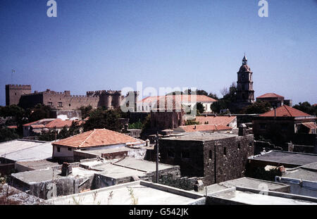 RHODES: Rooftops in the old city of Rhodes. In the distance is Palace of the Grand Masters, built by the Knight Hospitallers (Order of St. John). Rhodes was the most important base for the Order until the knights' expulsion by the Turkish Sultan, Suleiman the Magnificent, in 1522. The castle was heavily restored during the Italian occupation of the Dodecanese in the early 20th century. Stock Photo