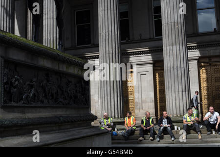 Construction workers sitting on a tea break outside the Gallery of Modern Art, in Glasgow, Scotland, UK. Stock Photo