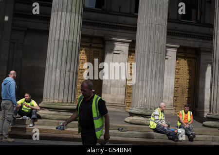 Construction workers sitting on a tea break outside the Gallery of Modern Art, in Glasgow, Scotland, UK. Stock Photo