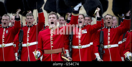 Members of the 1st Battalion and No. 7 Company the Coldstream Guards raise their bearskins as they give three cheers for the Queen Elizabeth II after being presented the colours at Windsor Castle. Stock Photo