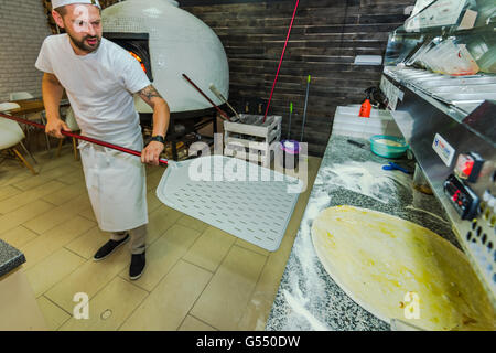 Bearded hipster chef prepare artisan pizza in traditional restaurant Stock Photo