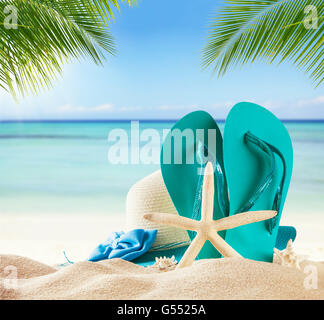 Summer accessories on sandy beach, blur sea on background. Summer exotic relaxation concept. Copyspace for text Stock Photo