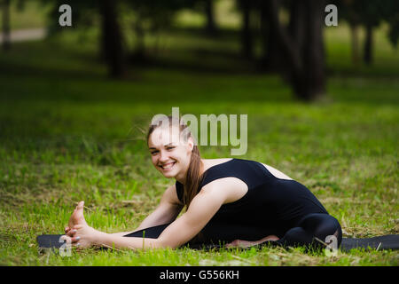 Woman stretching outdoors in a park before yoga practice Stock Photo