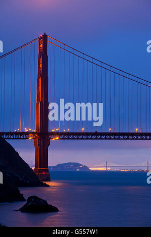 San Francisco Bay, CA, USA: Golden Gate Bridge, Bay Bridge, Yerba Buena Island, Port of Oakland, from Kirby Cove, dusk Stock Photo