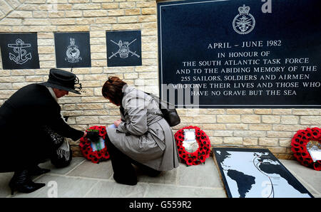 Two women lay a wreath at the new memorial commemorating the 255 British servicemen who died in the Falklands War, unveiled at the National Memorial Arboretum in Staffordshire. Stock Photo