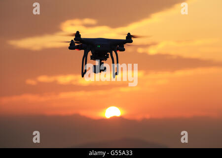 Drone flying against a sunset sky Stock Photo